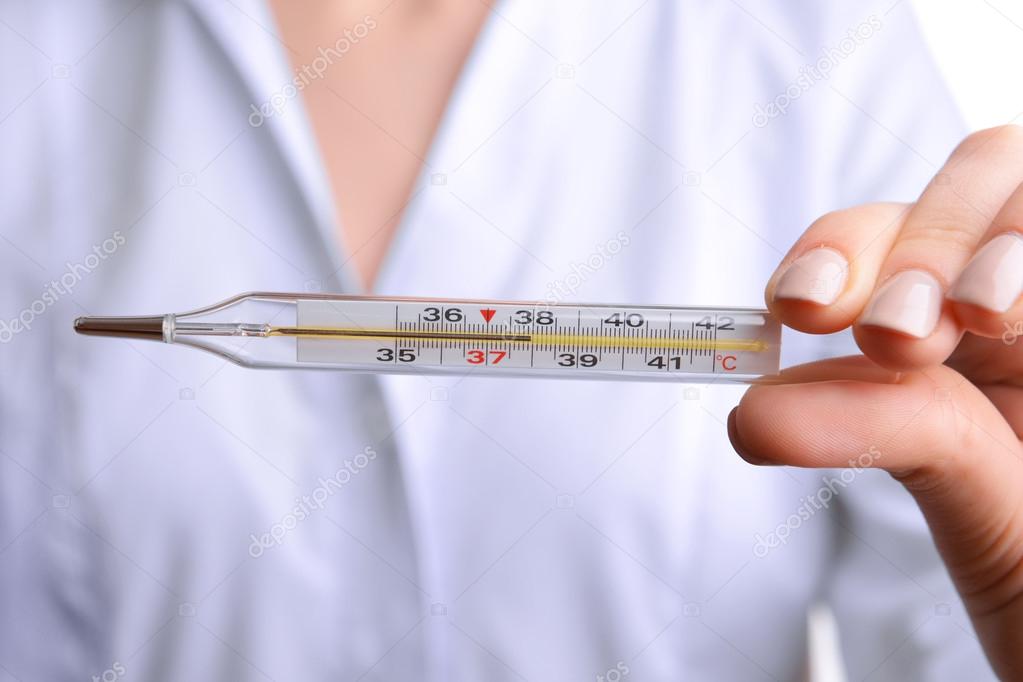 Doctor holding thermometer close up