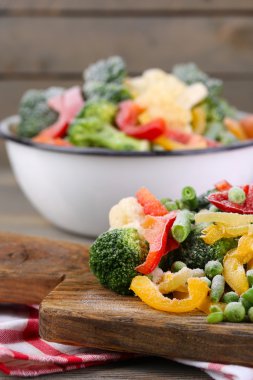 Peçeteye ahşap masa arka plan üzerinde kesme tahtası üzerinde Dondurulmuş sebzeler