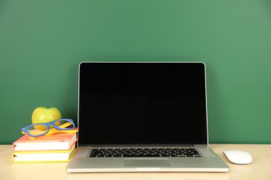 Masada yeşil yazı tahtası arka plan üstünde laptop