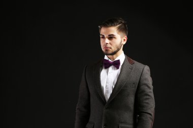Koyu arka plan üzerinde takım elbiseli şık adam