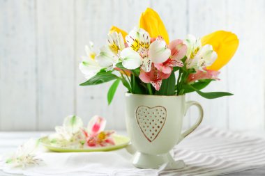 Kupası ahşap zemin üzerine güzel çiçekler