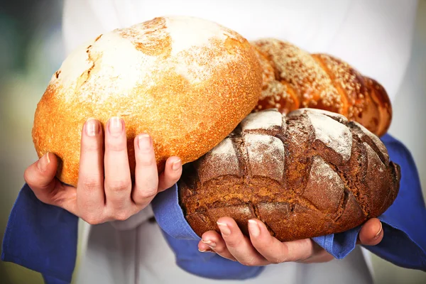 Manciata di pane fresco in mani femminili su sfondo chiaro sfocato — Foto Stock