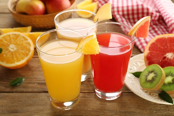 Jugos frescos con frutas en mesa de madera — Foto de Stock