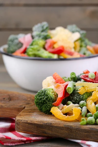 Peçeteye ahşap masa arka plan üzerinde kesme tahtası üzerinde Dondurulmuş sebzeler