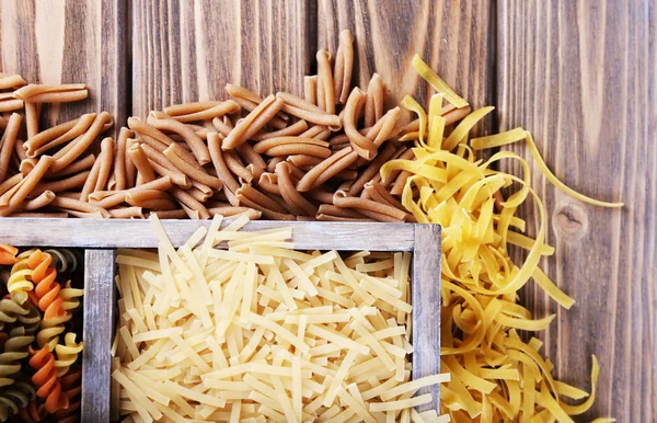 Verschiedene Arten von Pasta in Schachtel auf Holzgrund — Stockfoto