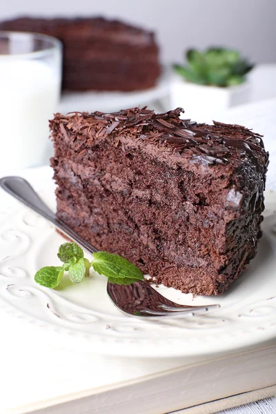 Gesneden lekkere chocolade cake in plaat op houten tafel, close-up — Stockfoto