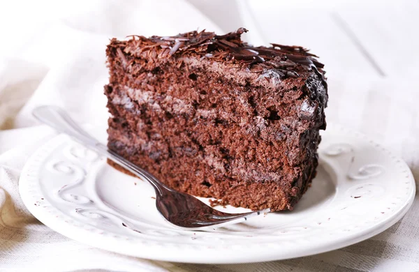 Sliced tasty chocolate cake in plate on wooden table, closeup — Stock Photo, Image