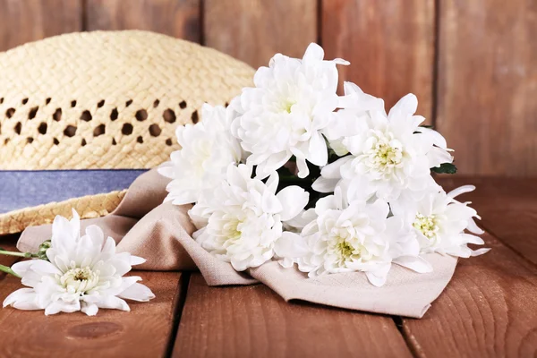 Hut mit Blumen auf Holzgrund — Stockfoto