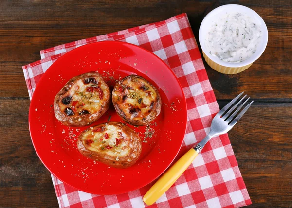 Patatas al horno en el plato y salsa en la mesa de cerca — Foto de Stock