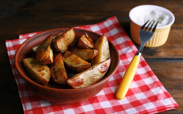 Batatas assadas em tigela e molho na mesa de perto — Fotografia de Stock