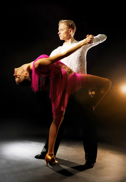 Schönes Paar professioneller Künstler, die auf schwarzem Hintergrund tanzen — Stockfoto