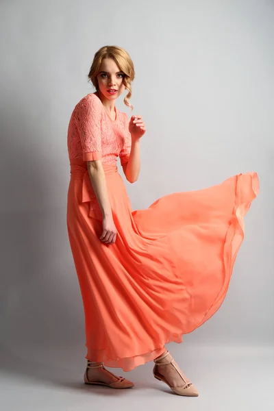 Mulher bonita em vestido de cor posando no fundo claro — Fotografia de Stock