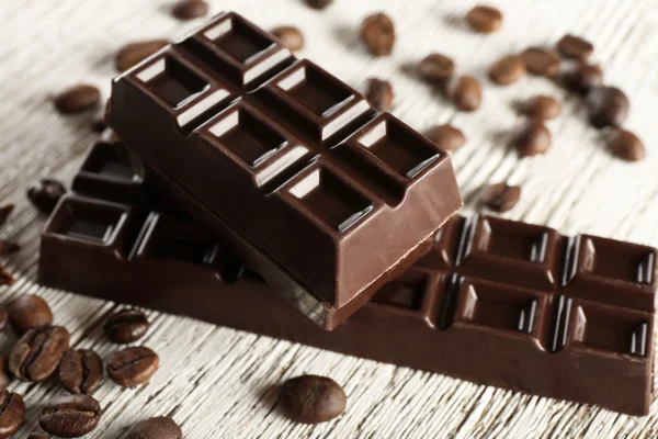 Gevulde chocolade met koffiebonen op houten tafel, close-up — Stockfoto