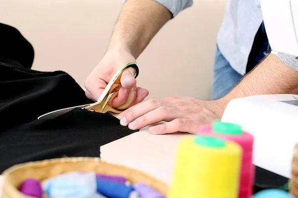 Male dressmaker cut fabric on table close-up — Stock Photo, Image