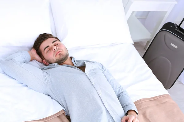 Tired man resting on bed — Stock Photo, Image