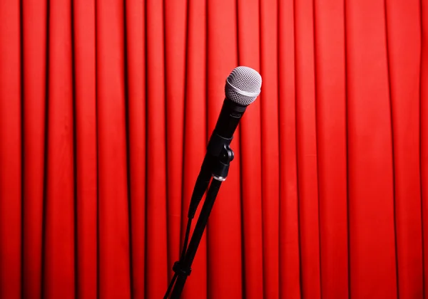 Мікрофон на підставці на фоні червоної завіси — стокове фото