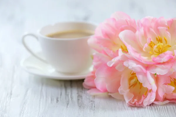 Roze tulpen met kop koffie op houten achtergrond — Stockfoto