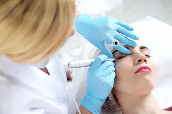 Cosmetólogo aplicando maquillaje permanente en los ojos, primer plano —  Fotos de Stock