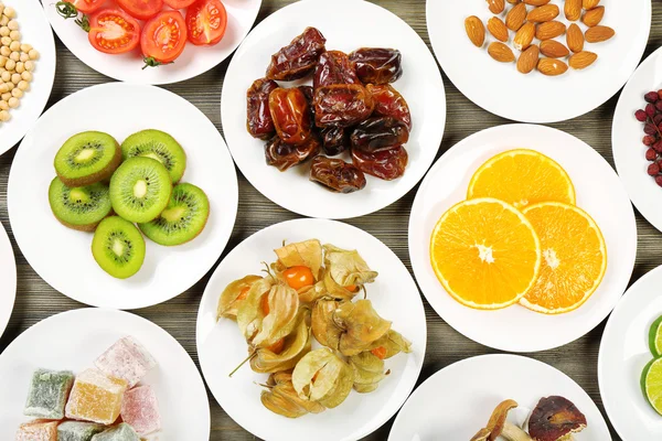 Different products on saucers on wooden table, top view — Stock Photo, Image