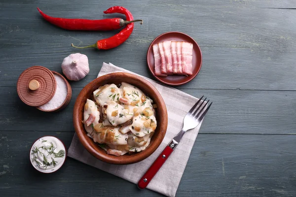 Albóndigas fritas con cebolla y tocino en sartén, sobre fondo de mesa de madera — Foto de Stock