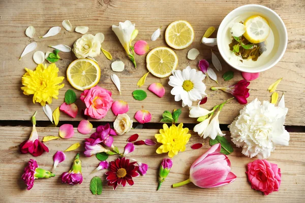 Xícara de chá de ervas com belas flores, em fundo de madeira — Fotografia de Stock