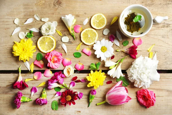 Taza de té de hierbas con hermosas flores, sobre fondo de madera — Foto de Stock