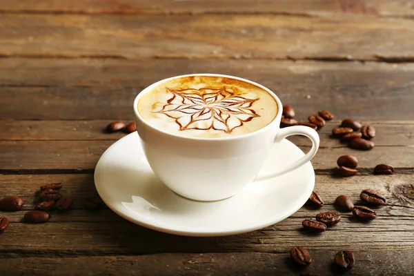 Latte art koffie met korrels op houten achtergrond kopje — Stockfoto