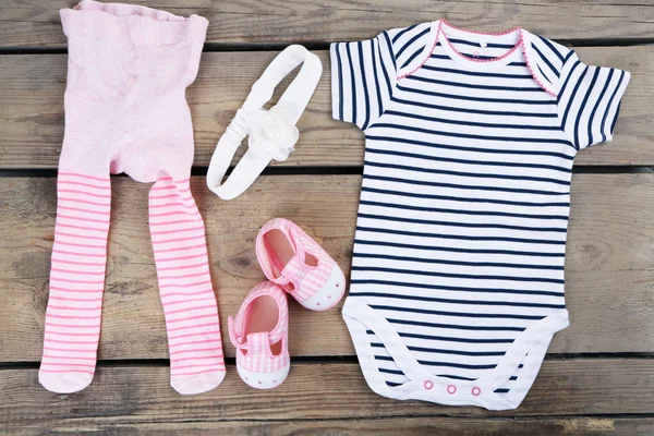 Vêtements pour bébé fille sur fond coloré — Photo