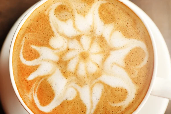Kopp kaffe latte art på träbord, närbild — Stockfoto