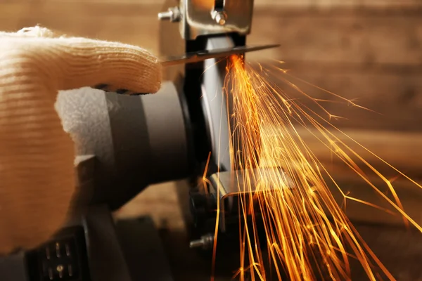 Messerschärfer und Hand mit Klinge auf Holztisch, Nahaufnahme — Stockfoto