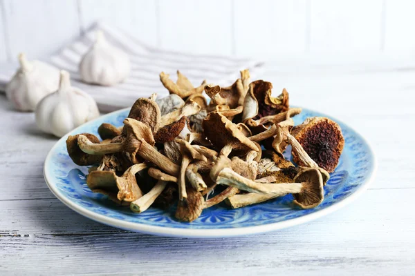 Gedroogde champignons in plaat op houten achtergrond — Stockfoto