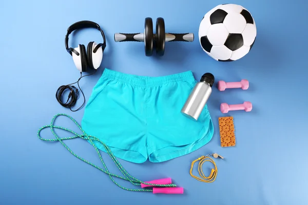 Sports equipment and shorts on color table, top view — Stock Photo, Image