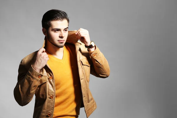 Portrait of young man on gray background — Stock Photo, Image