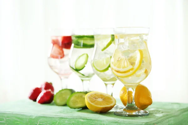 木製テーブルの上の異なる自家製新鮮健康ビタミン強化水のグラス — ストック写真