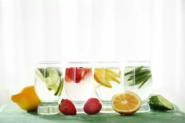 Glasses of different home made freshness healthy vitamin-fortified water on wooden table — Stock Photo, Image