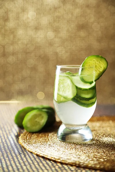 Verre d'eau fraîche avec concombre, sur fond lumineux — Photo