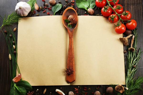 Open recipe book with fresh herbs, tomatoes and spices on wooden background — Stock Photo, Image