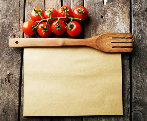 Folha de papel com tomate cereja em fundo de superfície de madeira rústica — Fotografia de Stock