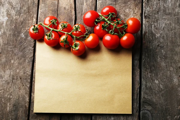 Feuille de papier avec tomates cerises sur fond rustique de surface en bois — Photo