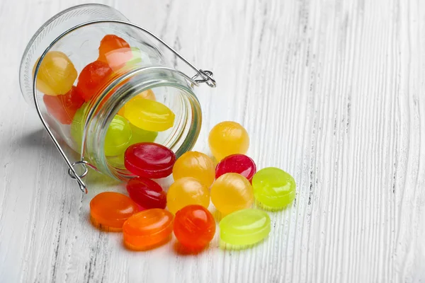 Bonbons colorés en pot sur fond en bois — Photo