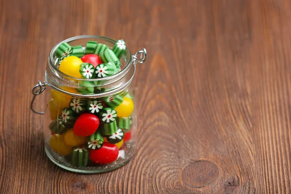 Bunte Bonbons im Glas auf Holzgrund — Stockfoto