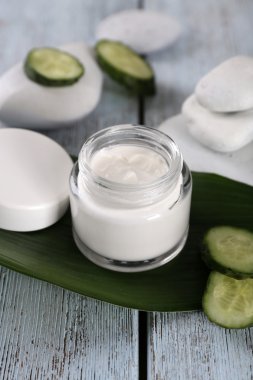 Kozmetik krem dilim salatalık ve spa taşlar ahşap arka plan üzerinde