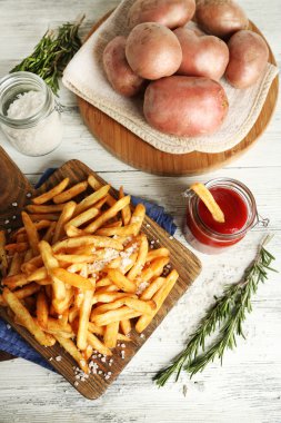 Tahtada patates kızartması, ahşap masa arkasında.