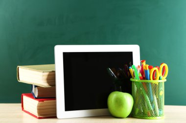 Dijital tablet, renkli kalemler ve elma