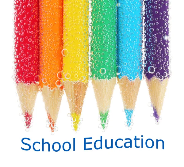 Farverige blyanter i vand med bobler, close- up - Stock-foto