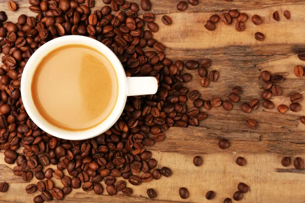 Secangkir kopi dengan biji-bijian di atas meja kayu pedesaan, pemandangan atas — Stok Foto