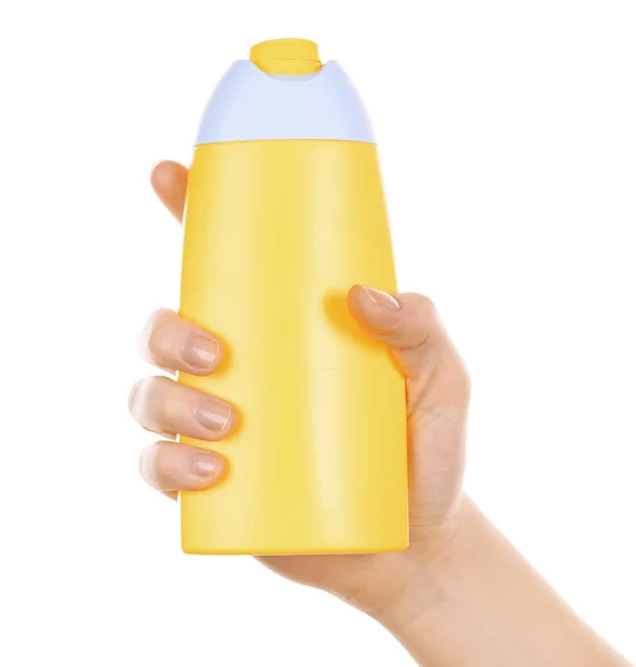 Bottle of suntan cream in female hand isolated on white — Stock Photo, Image