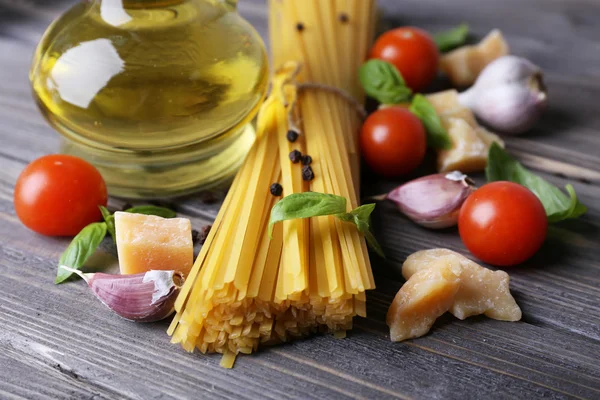 Raw pasta with cheese and vegetables on wooden background — Stock Photo, Image