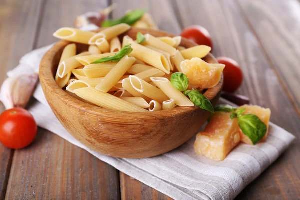 Ruwe pasta in de kom met kaas en groenten op tafel close-up — Stockfoto