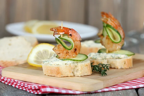 stock image Appetizer canape with shrimp and cucumber on table close up